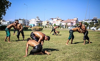 Güreşçiler, yol kenarındaki çimde antrenman yapıyor