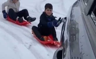 Korkuteli'nde otomobil arkasına bağlı kızakta çocukların kayak keyfi
