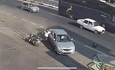 Kazada motosiklet sürücüsü çarpıştığı otomobilin kapısına tutunup sonra yere düştü